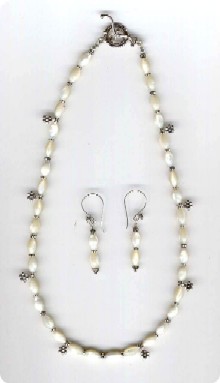 simple rang de perles de nacre relooké avec  des petites fleurs et des intercalairers en argent de Bali